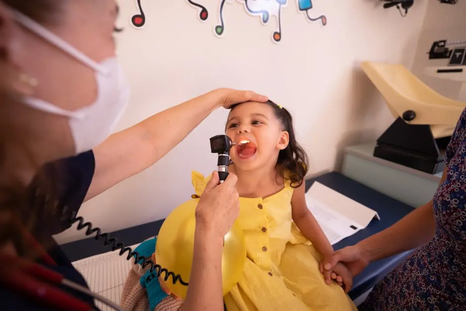 Pediatrician examines smiling child in a health clinic. Bright setting with friendly atmosphere.