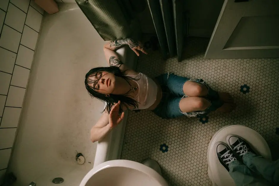 Young Woman Sitting on the Floor in the Bathroom and Looking Up