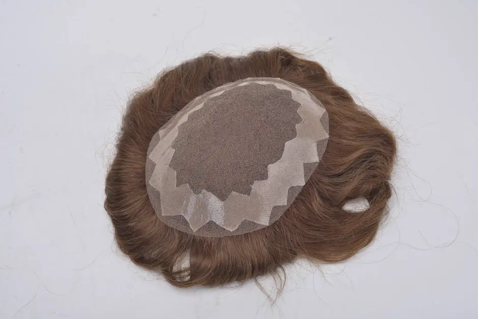 Close-up image of a brown hair wig on a white surface, showcasing texture and detail.