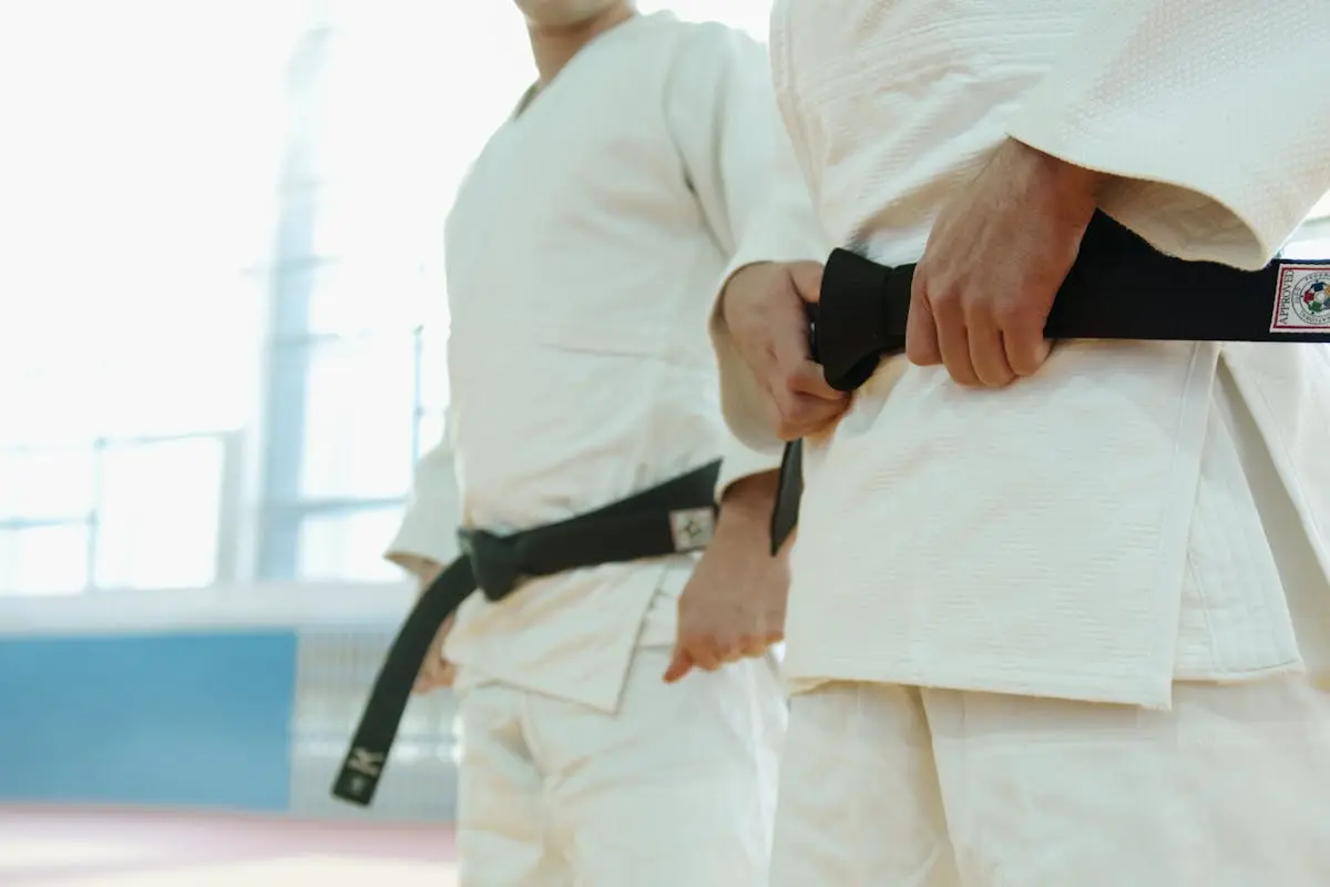 Close-Up Shot of Two People Wearing Karategi and Black Belt