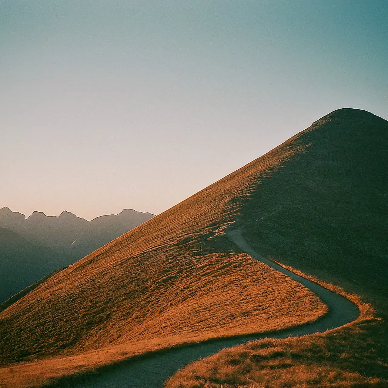 A winding path leading to a mountain peak at sunrise. 35mm stock photo