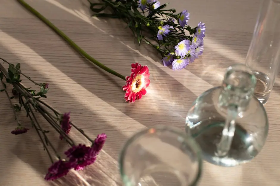 Glass vases arranged on wooden table with assorted fresh flowers