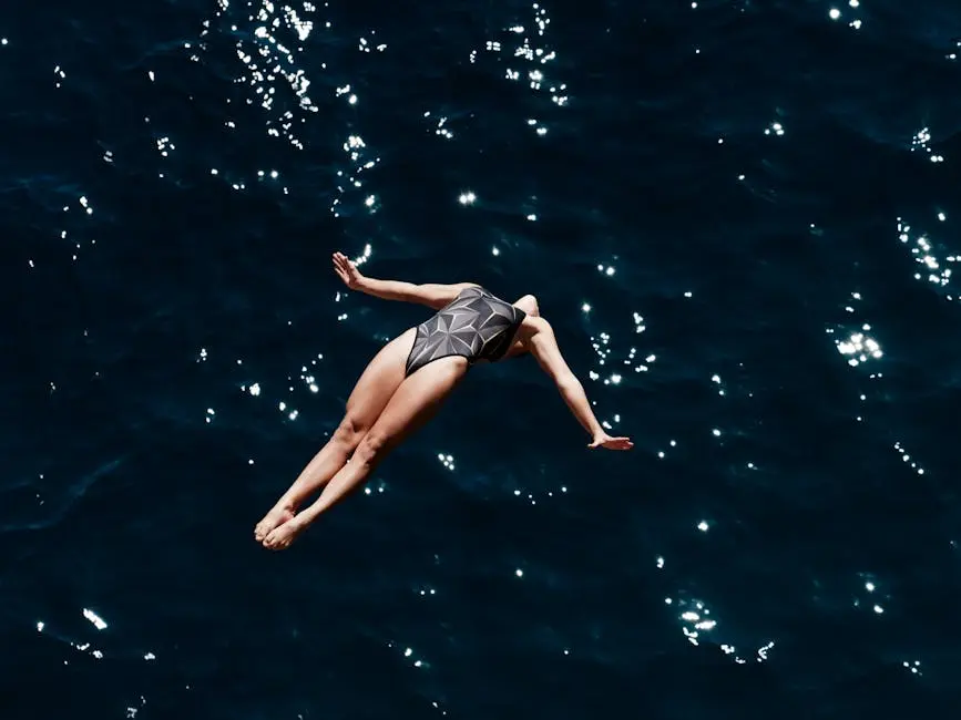 A woman in swimwear fearlessly dives into the deep blue ocean, showcasing grace and freedom.