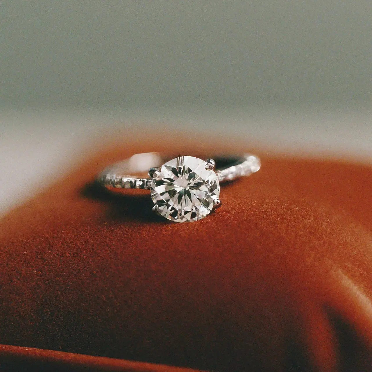 A sparkling lab-created diamond ring on a velvet cushion. 35mm stock photo