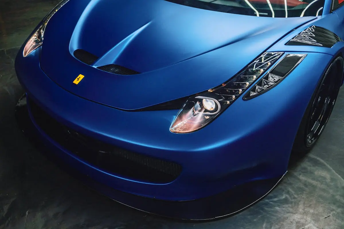 From above of stylish front bumper and glowing curvy headlights of modern luxury sports car