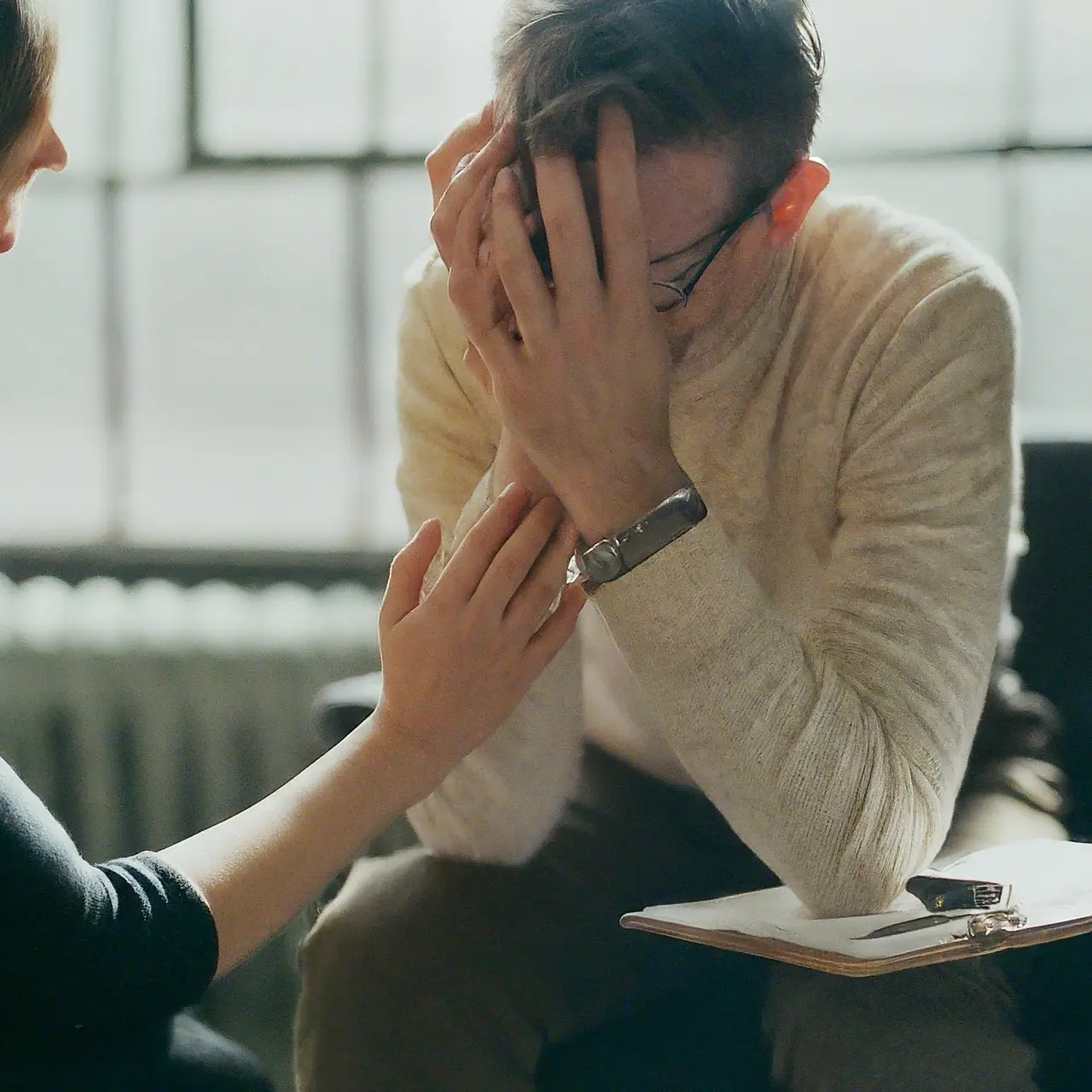 A compassionate psychiatrist comforting a distraught patient in an office. 35mm stock photo