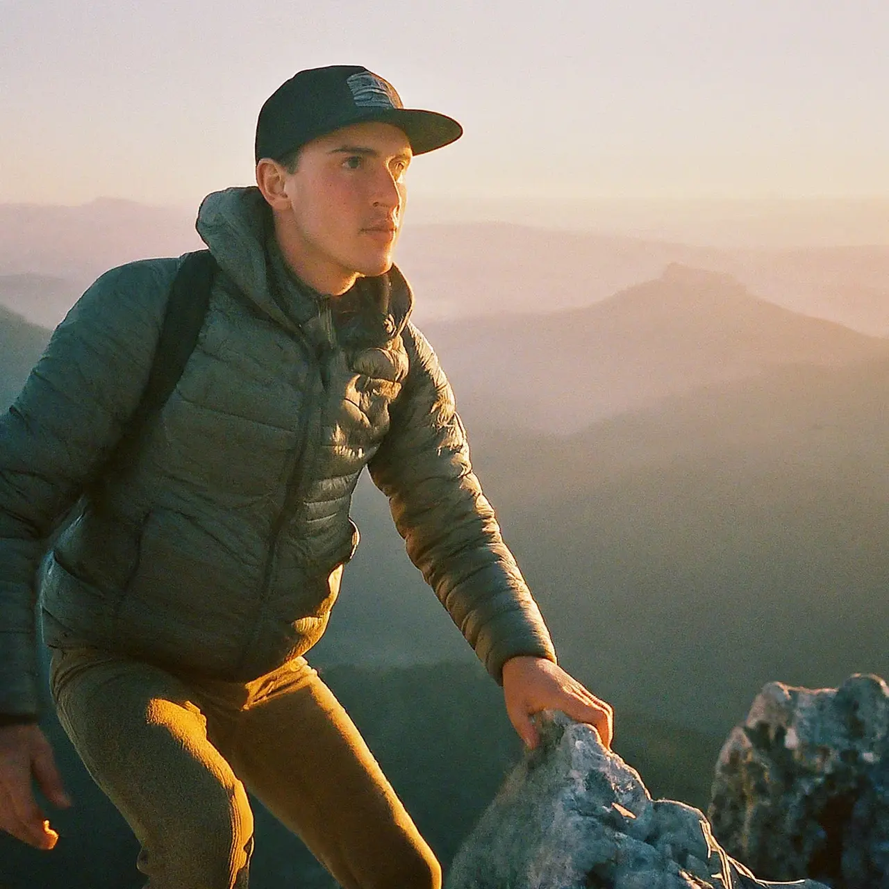 Leader climbing the top of a mountain at sunrise. 35mm stock photo