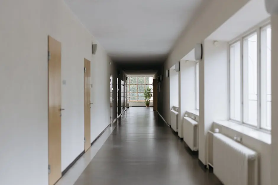 Spacious modern hallway with large windows and natural light reflecting off the floor.