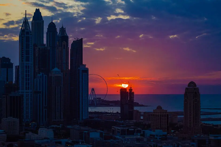 Breathtaking view of Dubai’s skyline at sunset, featuring iconic skyscrapers and a serene Ferris wheel over the water.