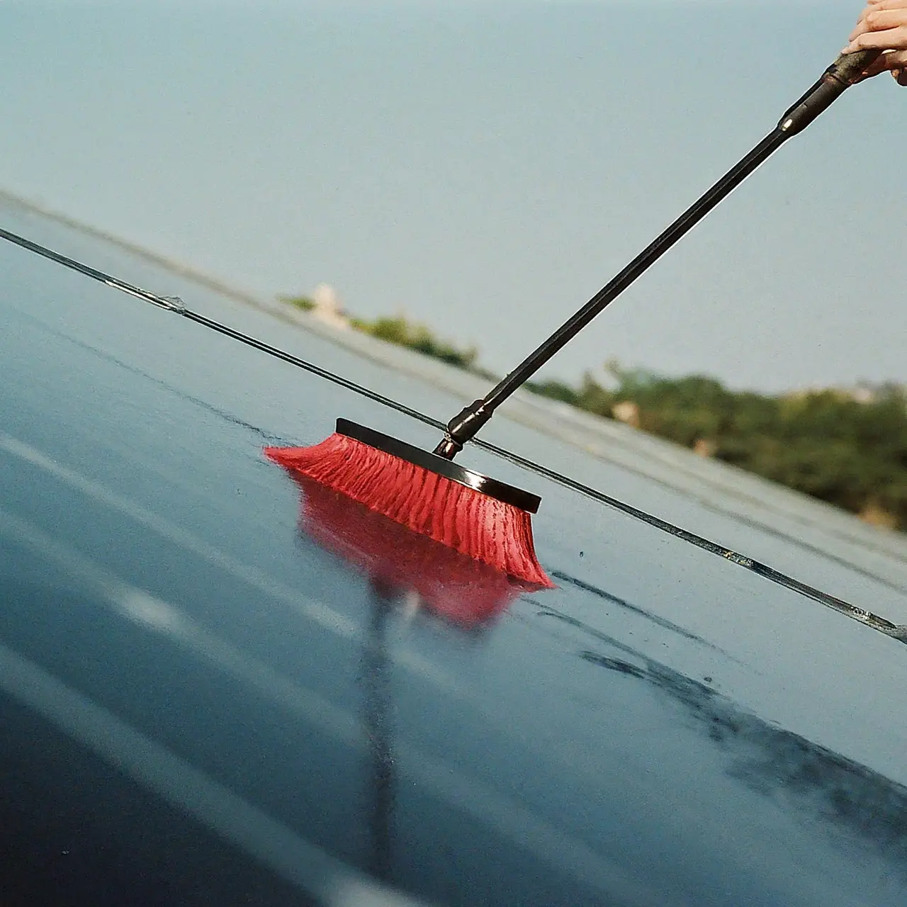 Solar panels being cleaned with water and a brush. 35mm stock photo