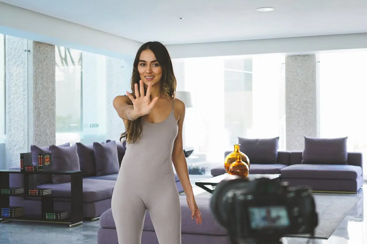 A Woman in Gray Jumpsuit Standing while Vlogging