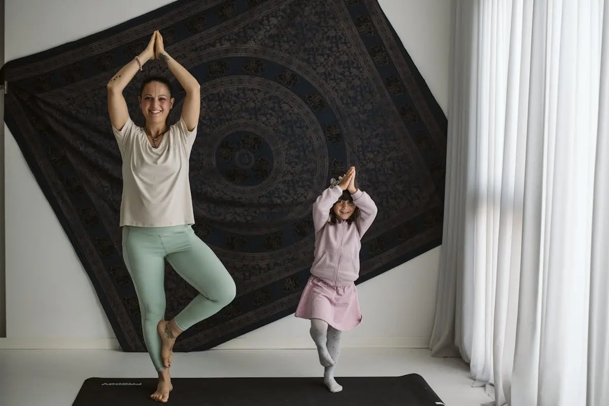 A mom and her daughter perform yoga poses in a cozy home setting, fostering fitness and bonding.