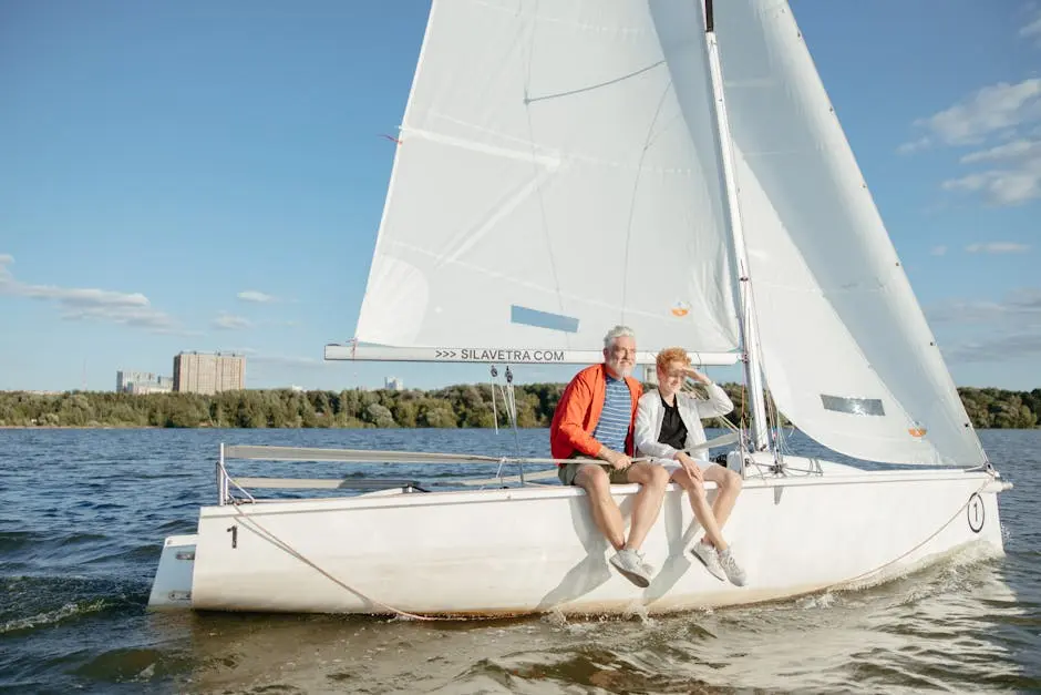 A grandfather and grandson enjoy a bonding moment sailing on a sunny day.