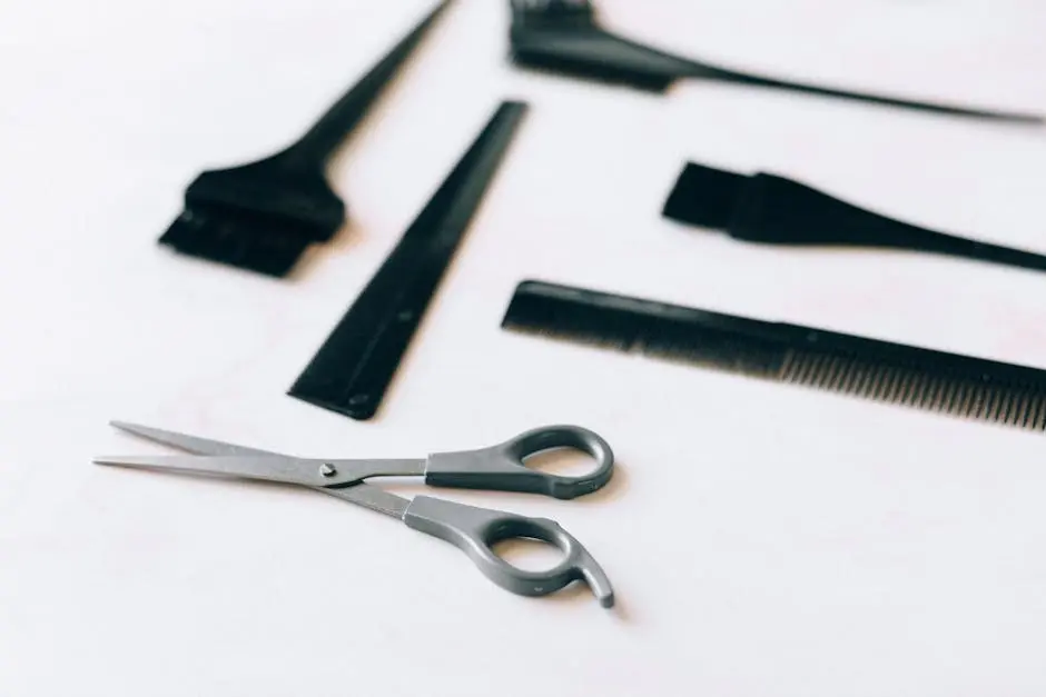 A collection of essential hairdressing tools including scissors and combs on a white surface.