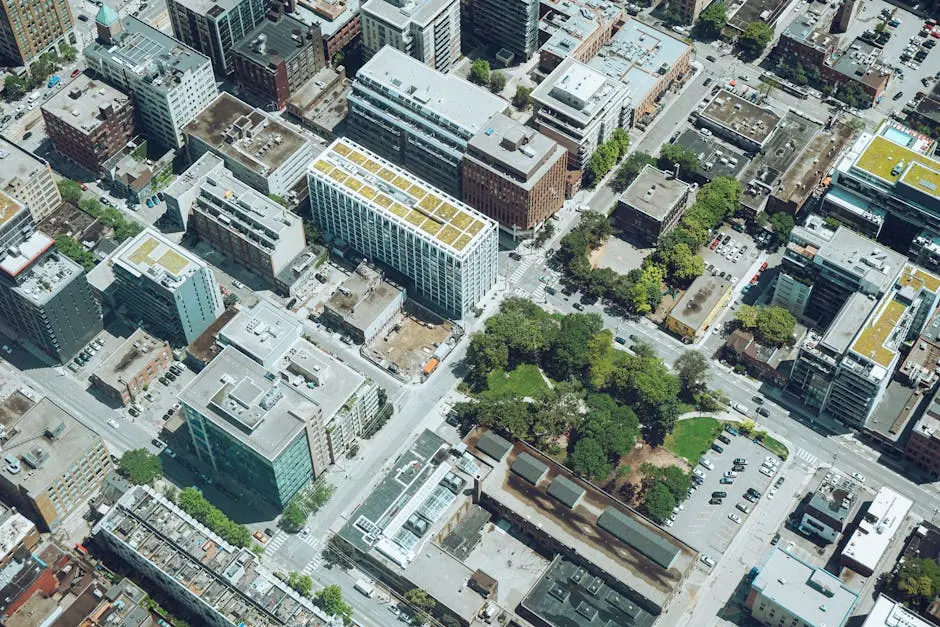 Drone view modern city area with contemporary apartment buildings and landscaped public territories on sunny day