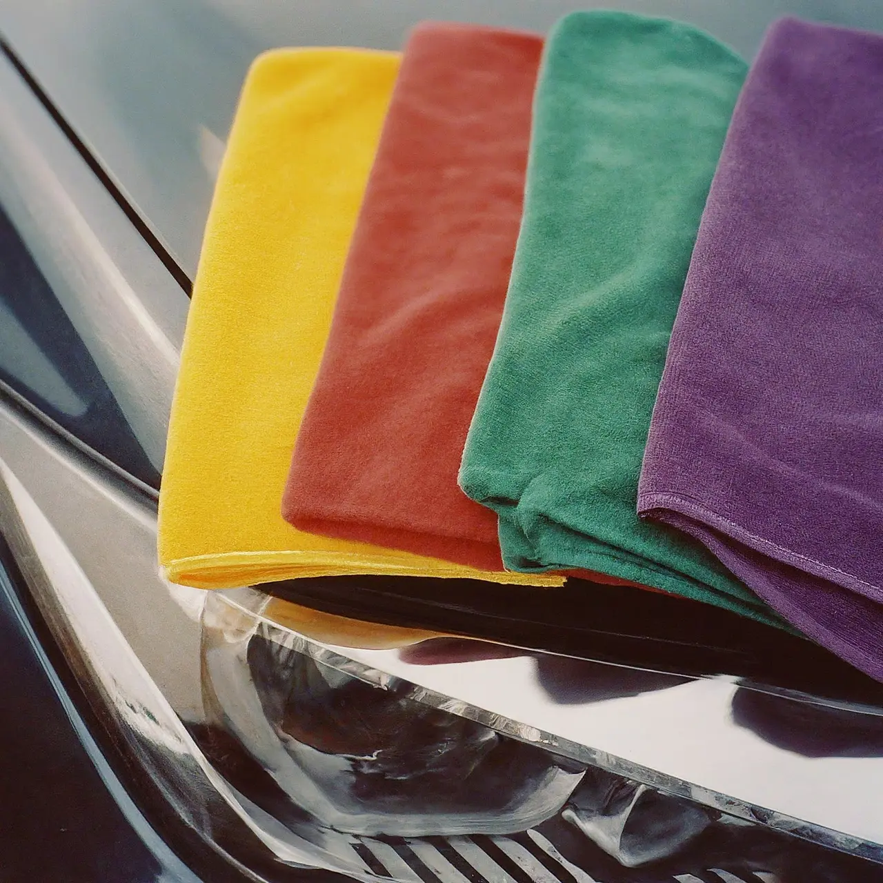 Close-up of colorful microfiber towels on a car hood. 35mm stock photo