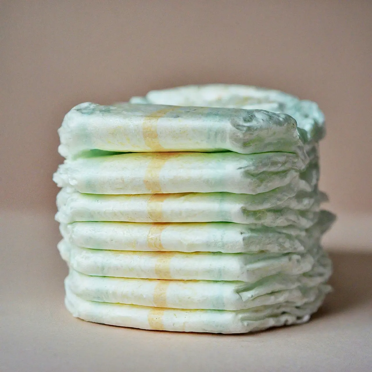 A stack of diapers on a soft, pastel background. 35mm stock photo