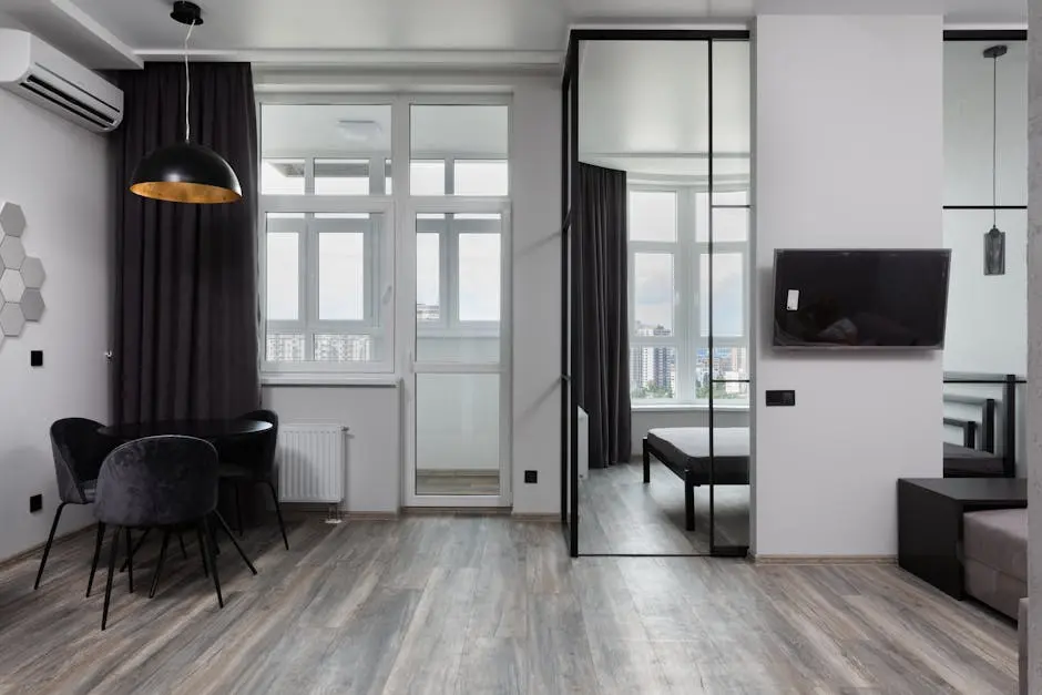 Contemporary room interior with chairs under lamp and air conditioning in light house with glass wall