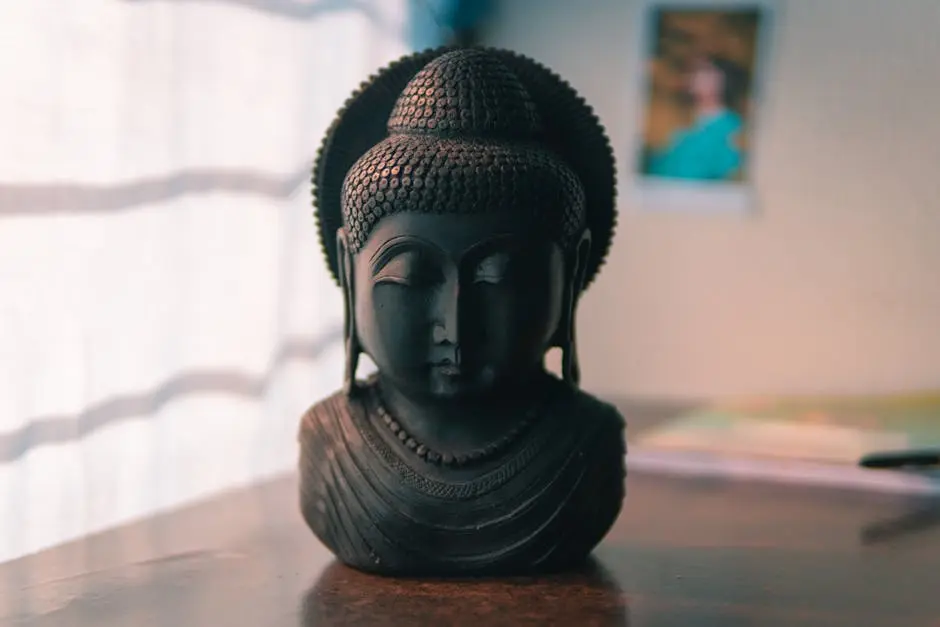 Sculpted Buddha figurine on a table, radiating calm in soft ambient light.