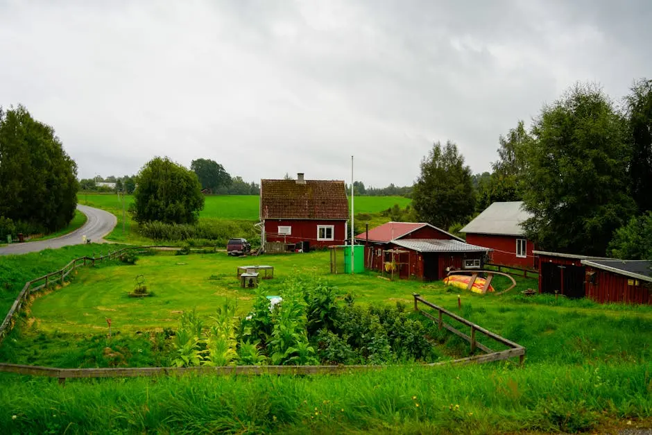 Charming red farmhouse in a lush green countryside setting, perfect for rural living themes.