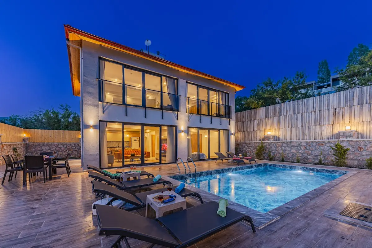 A large house with a pool and lounge chairs