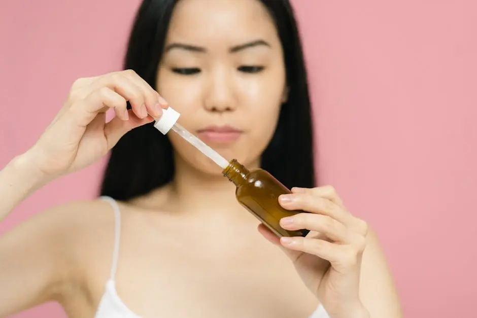 Close-up of a woman holding a serum bottle with a dropper, focusing on skincare.