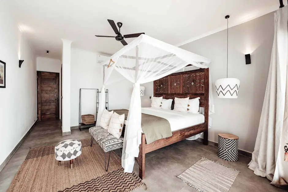 Wooden Carved Bed with White Canopy and Rugs in a Bedroom