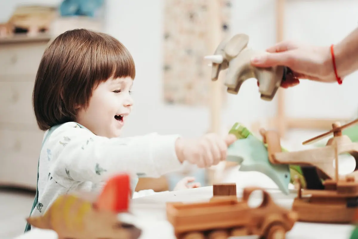 Child Playing With Green Plastic dragon toy being taught by her mom