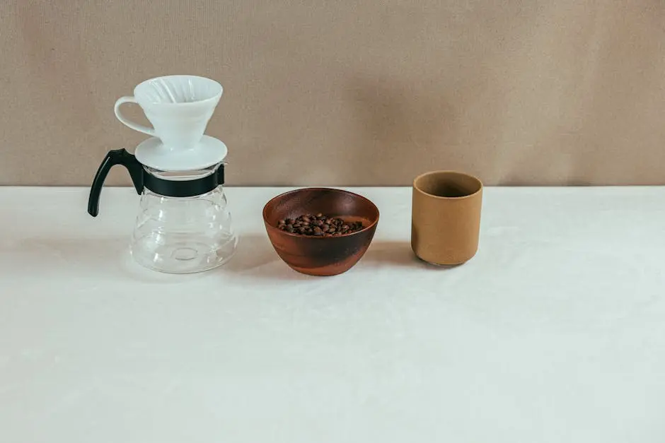 Stylish minimalist coffee setup featuring a drip brewer, coffee beans, and a cup.