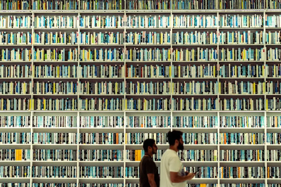 Two men explore large bookshelves with diverse titles in a Dubai library.