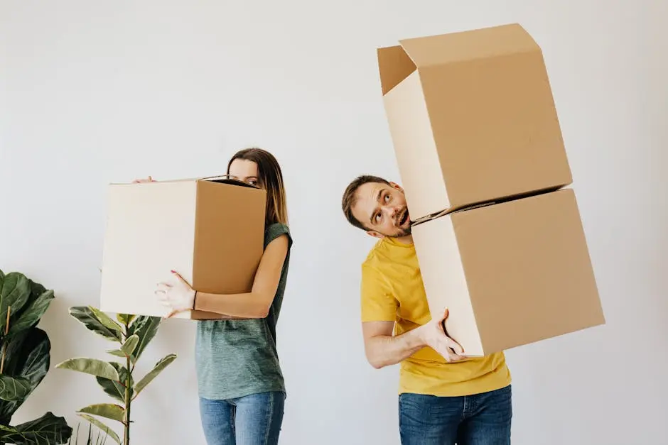 Una feliz pareja cargando cajas mientras se traslada a su nuevo hogar.