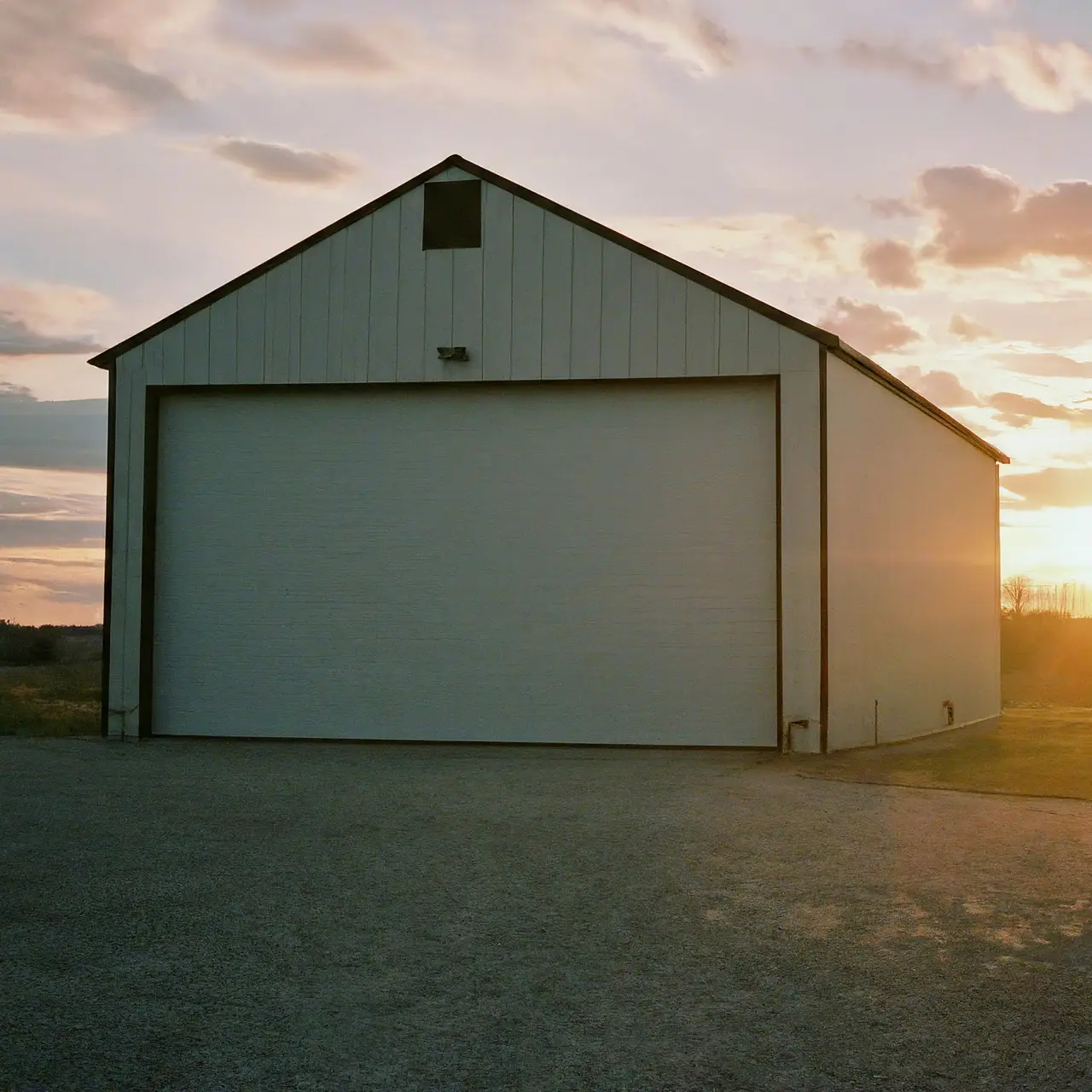 A sturdy commercial shed set against a sunset. 35mm stock photo