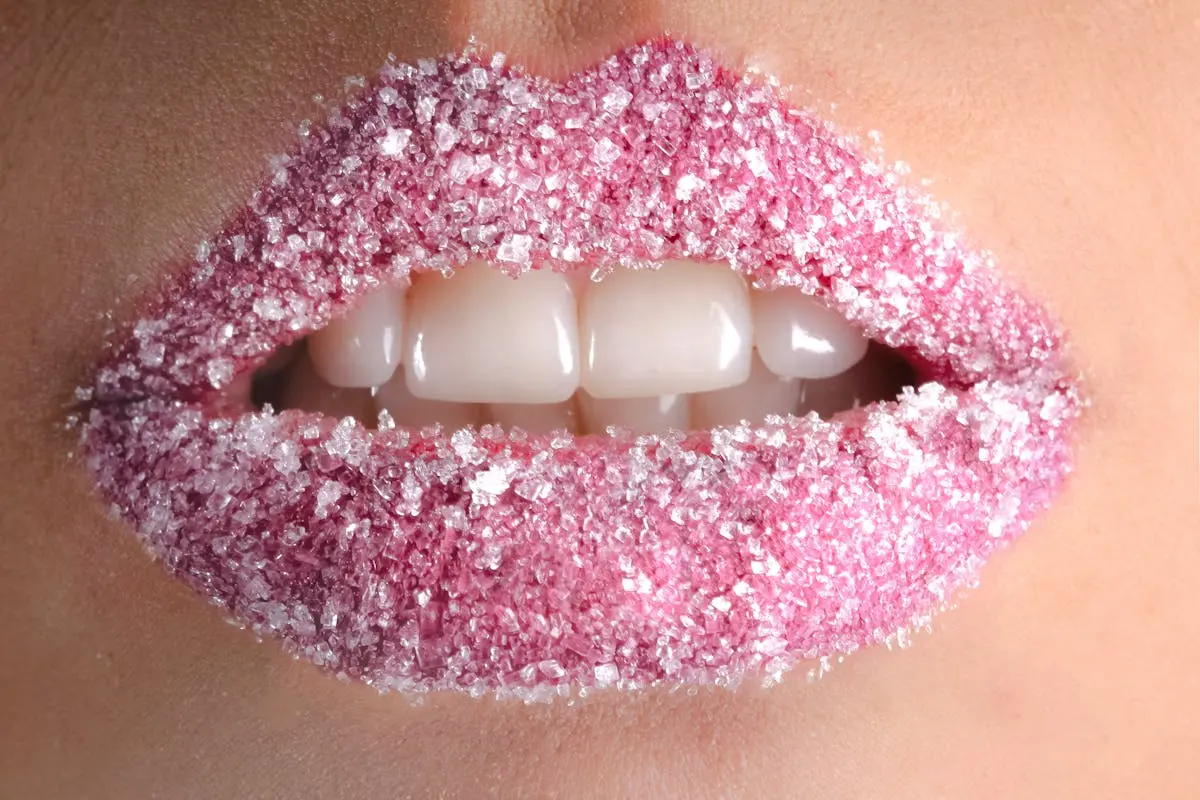 Artistic close-up of lips coated with pink sugar crystals, showcasing beauty and creativity.