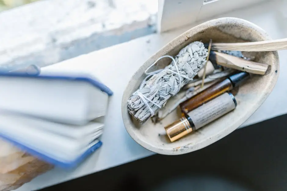 A calming arrangement of healing crystals, sage, and essential oils on a windowsill for spiritual rituals.