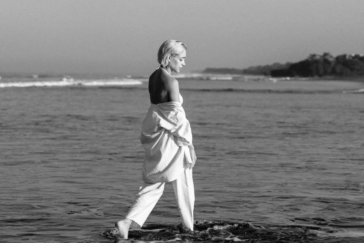 A woman in white walking in the ocean